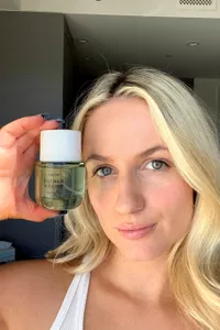 A person holding a bottle of Phlur Father Figure
