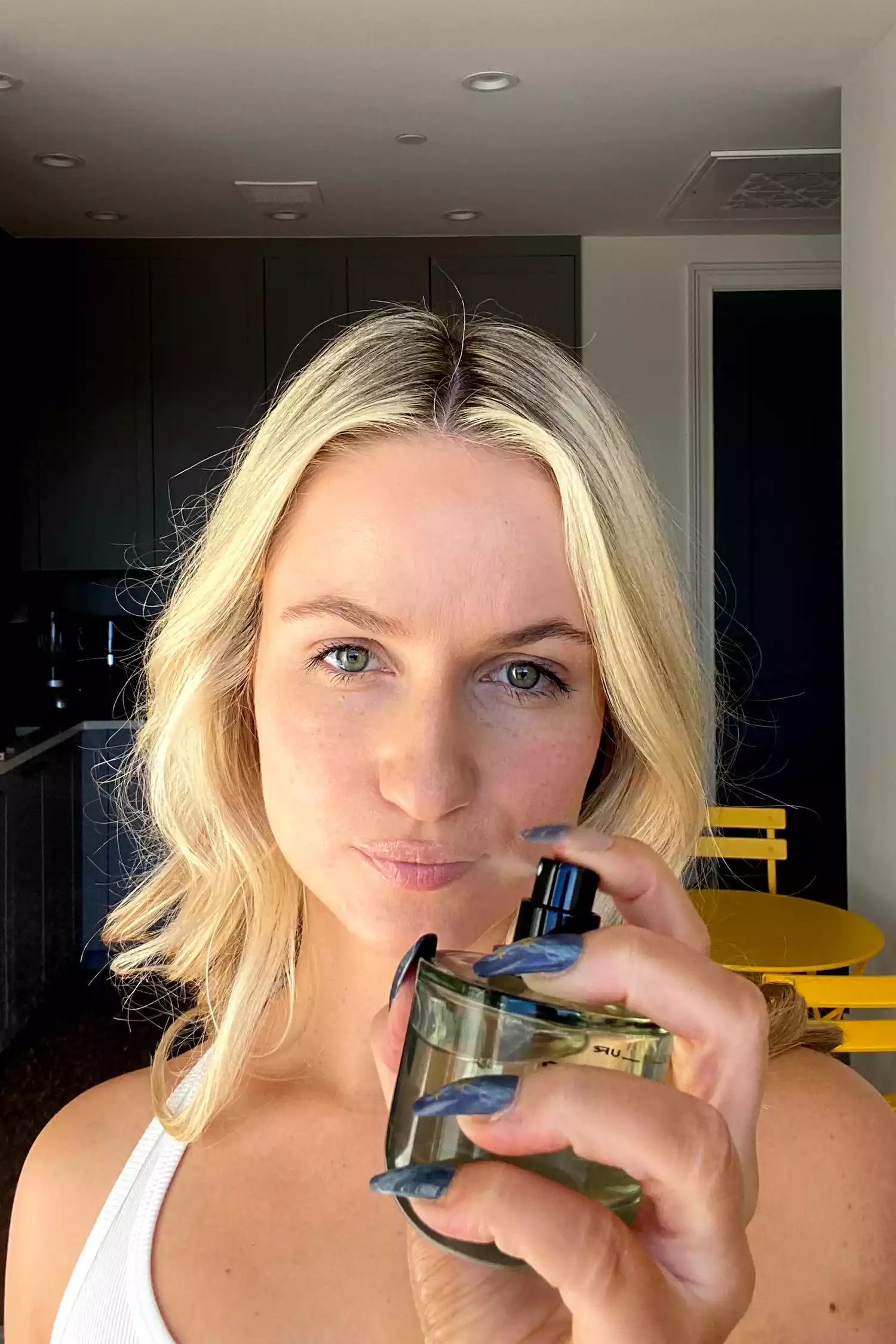 A person spraying Phlur Father Figure